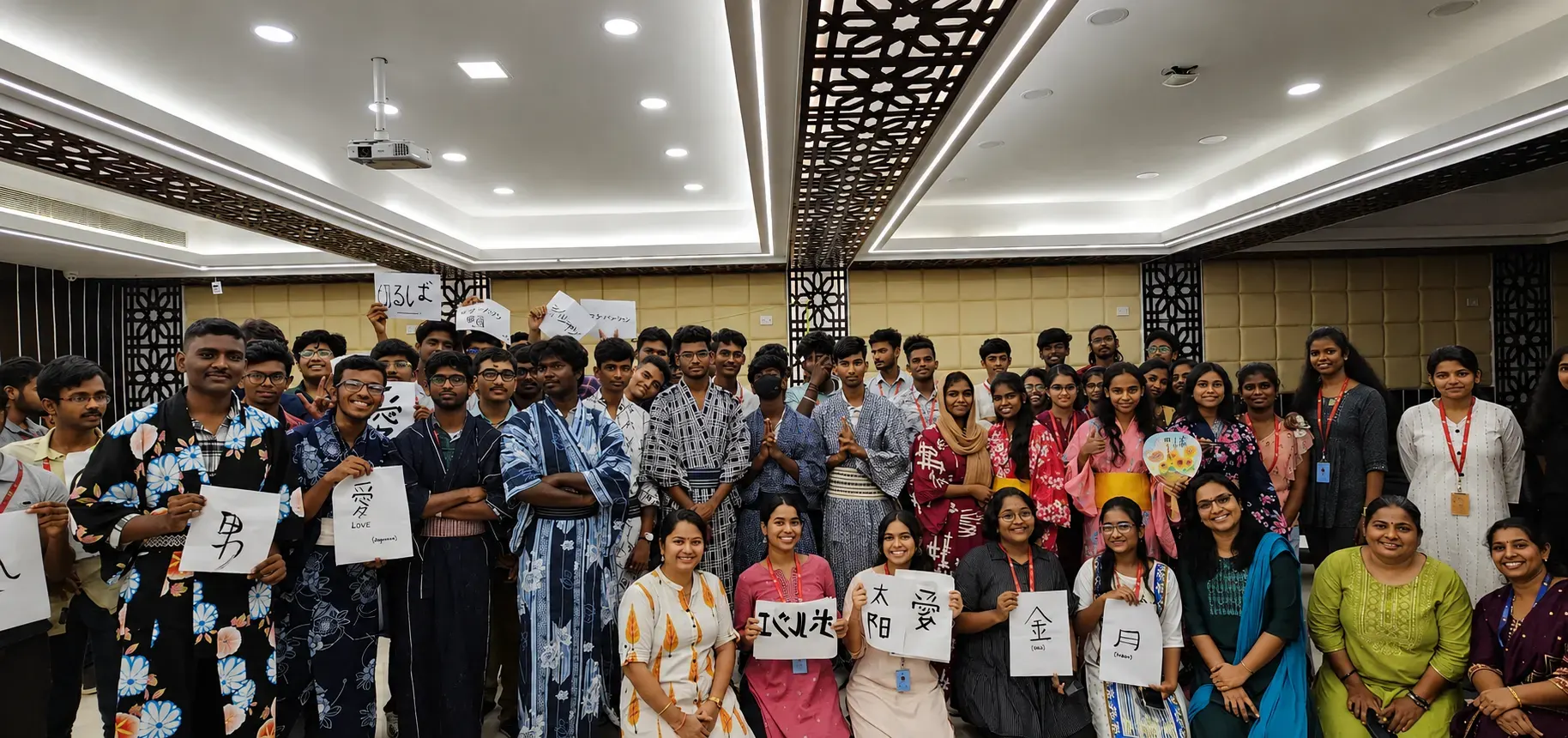 A large student group in yukata holding handwritten kanji cards